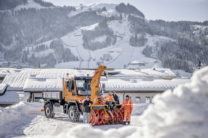 Vier Mann im Schnee und ihr Unimog